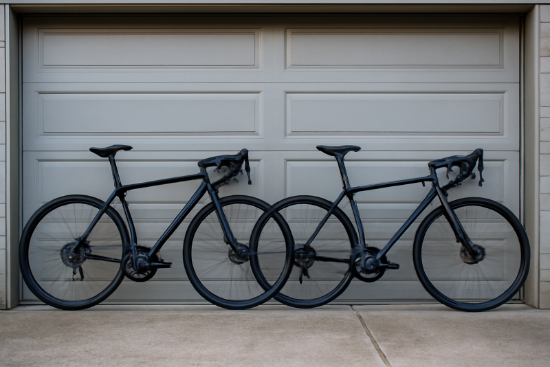 deux vélos de route alignés devant garage