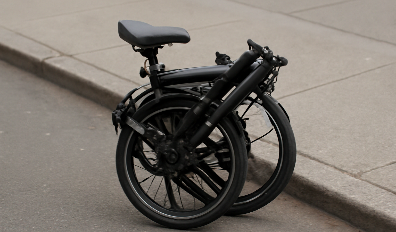 vélo pliant replié posé sur trottoir